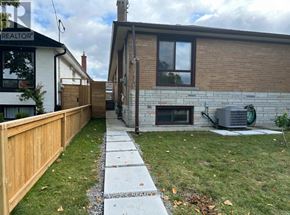 Toronto (Markland Wood) apartment for rent - A house with a wooden fence and a brick wall with a window and a door.