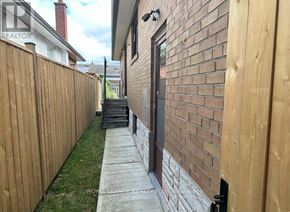 Toronto (Markland Wood) apartment for rent - A brick wall with a black door and a wooden fence.