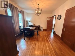 Windsor apartment for rent - A wooden table with chairs in a room with a hanging light fixture.