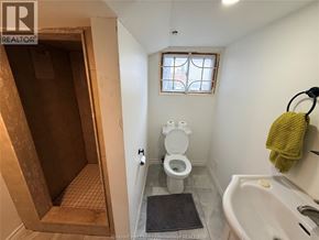 Windsor apartment for rent - A bathroom with a toilet, a window, and a sink.