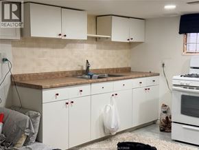 Windsor apartment for rent - A kitchen with white cabinets and a brown countertop.