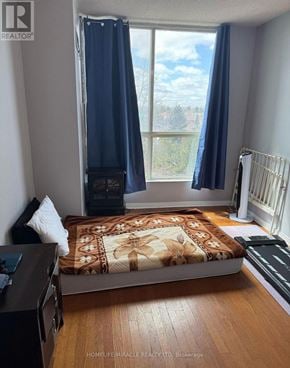 Toronto (Mount Olive-Silverstone-Jamestown) house for rent - A bedroom with a bed, a dresser, and a window with blue curtains.