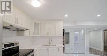 Brampton (Northwest Brampton) apartment for rent - A kitchen with white cabinets and a black stove top oven.