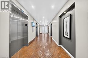 Hamilton condo for rent - A hallway with wood flooring and a glass elevator.