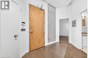 Hamilton condo for rent - A living room with a black couch and a white rug.
