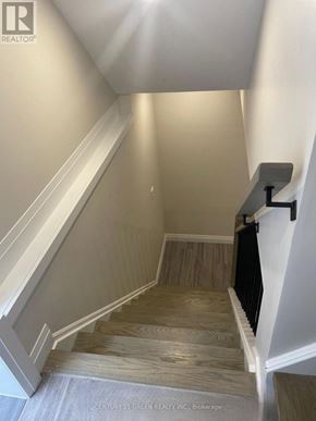 Kitchener apartment for rent - A staircase with wooden steps and a black handrail.