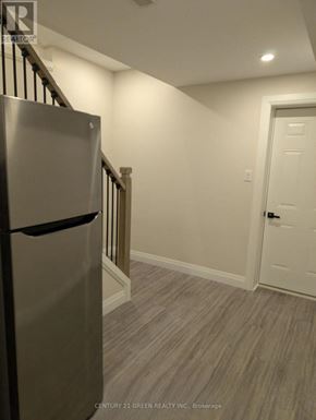Kitchener apartment for rent - A kitchen with a stainless steel refrigerator and a white door.