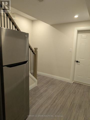 Kitchener apartment for rent - A kitchen with a stainless steel refrigerator and a white door.