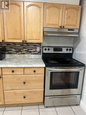 Hamilton (Winona Park) apartment for rent - A kitchen with wooden cabinets and a stove top oven.