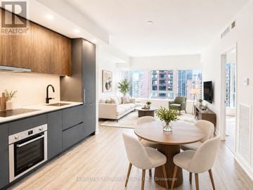 Toronto (North St. James Town) condo for rent - A modern kitchen with a dining table set for four.