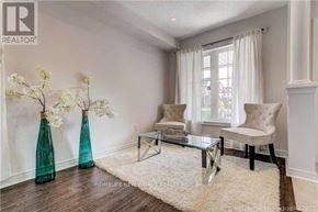 Markham (Greensborough) townhouse for rent - A living room with a white sofa, a glass coffee table, and two green vases with white flowers.
