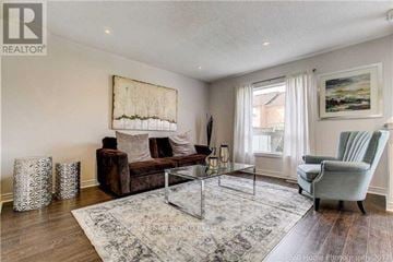 Markham (Greensborough) townhouse for rent - A living room with a brown couch, a glass coffee table, and a painting on the wall.