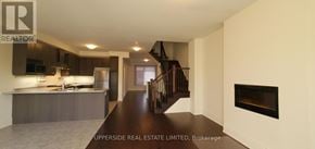 Newmarket (Woodland Hill) townhouse for rent - A spacious kitchen with a bar area and a staircase.