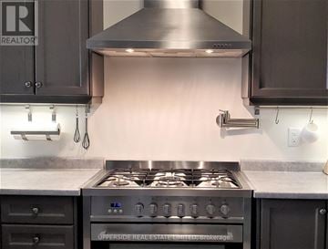 Newmarket (Woodland Hill) townhouse for rent - A modern kitchen with a stove top oven and a range hood.
