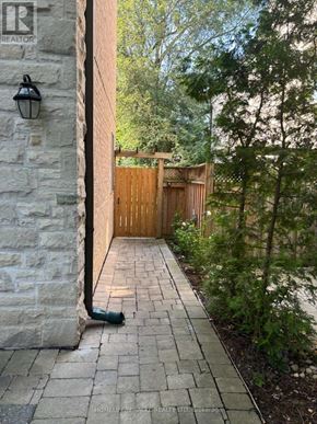 Toronto (Edenbridge-Humber Valley) apartment for rent - A stone pillar with a lantern on top is on the left side of a wooden gate.