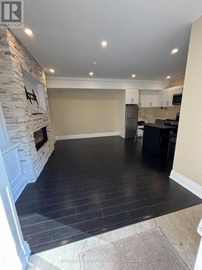 Toronto (Edenbridge-Humber Valley) apartment for rent - A stone fireplace in a room with a black floor.