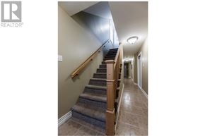 St. John's house for rent - A staircase with a wooden handrail and a carpeted runner.
