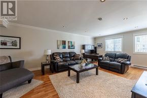 St. John's house for rent - A living room with a grey sofa, a black leather couch, a coffee table, and a television.