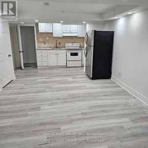 Richmond Hill (Devonsleigh) apartment for rent - A kitchen with white cabinets and a black refrigerator.