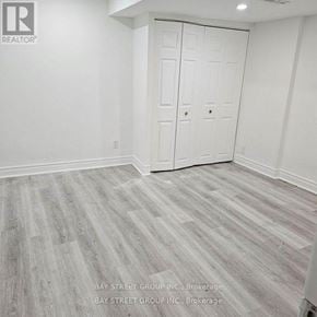 Richmond Hill (Devonsleigh) apartment for rent - A room with white walls and a wooden floor.