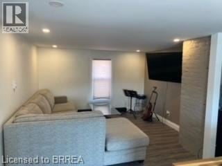 Brantford apartment for rent - A living room with a grey couch and a black vacuum cleaner.