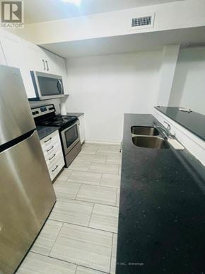 Kitchener townhouse for rent - A kitchen with a stainless steel refrigerator, microwave, oven, and dishwasher.