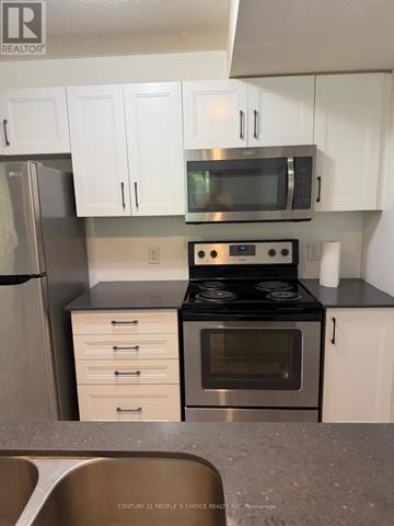Kitchener townhouse for rent - A kitchen with white cabinets and a black stove top.