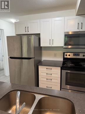Kitchener townhouse for rent - A kitchen with a stainless steel refrigerator, oven, and microwave.