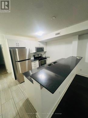 Kitchener townhouse for rent - A kitchen with white cabinets and a black counter top.
