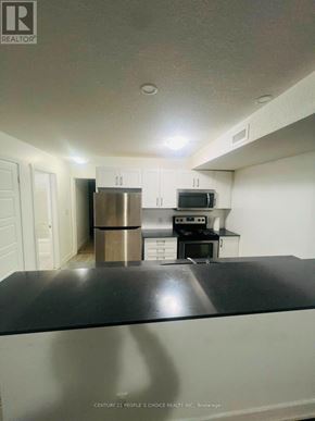 Kitchener townhouse for rent - A kitchen with a black countertop and stainless steel appliances.