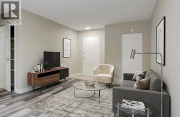 Cambridge apartment for rent - A living room with a grey couch, a glass coffee table, and a television on a wooden stand.