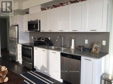 Toronto (Waterfront Communities) condo for rent - A kitchen with white cabinets and a black countertop.