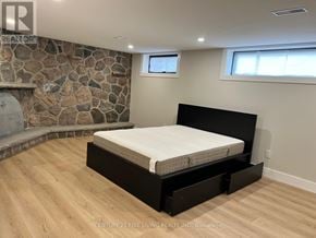 Toronto (Willowridge-Martingrove-Richview) apartment for rent - A bedroom with a stone fireplace and a large bed.
