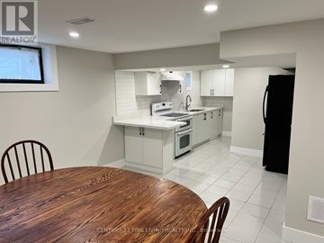 Toronto (Willowridge-Martingrove-Richview) apartment for rent - A kitchen with a wooden table and a black refrigerator.