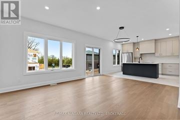 Niagara Falls (Marineland) apartment for rent - A spacious living room with a kitchen area in the background.