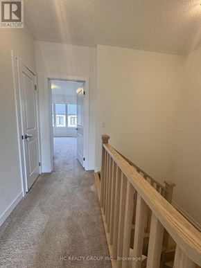 Markham (Angus Glen) townhouse for rent - A hallway with a carpeted floor and white walls.