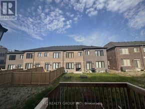 Markham (Angus Glen) townhouse for rent - A building complex with a fence and a grassy area in front.