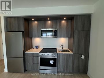 Toronto (Islington-City Centre West) condo for rent - A modern kitchen with dark wood cabinets and stainless steel appliances.