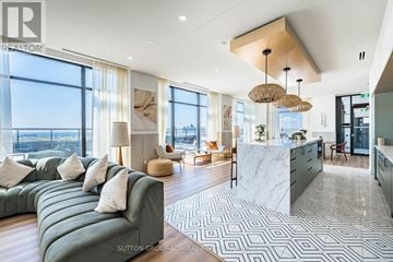 Toronto (High Park North) condo for rent - A modern living room with a large green sofa and a marble countertop.