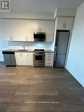 Hamilton (Beasley) condo for rent - A kitchen with white cabinets and a wooden floor.
