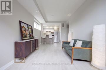Burlington (Lasalle) townhouse for rent - A living room with a couch, a side table, and a painting on the wall.