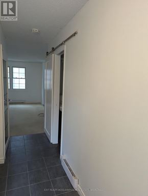 Kingston (Central City West) townhouse for rent - A hallway with a door on the right and a window on the left.