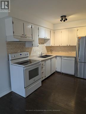 Kingston (Central City West) townhouse for rent - A kitchen with white appliances and cabinets.