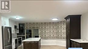 Toronto (Kennedy Park) condo for rent - A kitchen with a refrigerator, microwave, and cabinets.