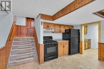 New Tecumseth (Alliston) apartment for rent - A kitchen with wooden cabinets and a black refrigerator.