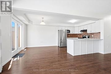 London South (South W) townhouse for rent - A spacious kitchen with white cabinets and a brick backsplash.