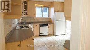 Toronto (Malvern) apartment for rent - A kitchen with a white fridge and wooden cabinets.