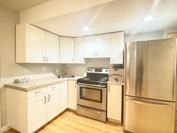 Surrey apartment for rent - A kitchen with white cabinets and stainless steel appliances.