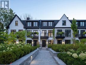 Mississauga (Mineola) townhouse for rent - A modern house with a black and white exterior and a stone pathway leading to the entrance.