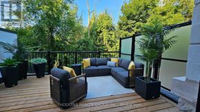 Mississauga (Mineola) townhouse for rent - A patio with a couch, chairs, and a table with a potted plant on it.